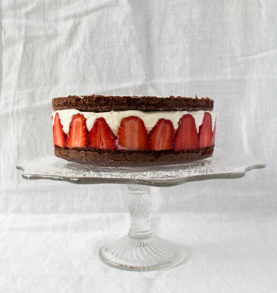 Chocolate cake with strawberries and cream on cake stand
