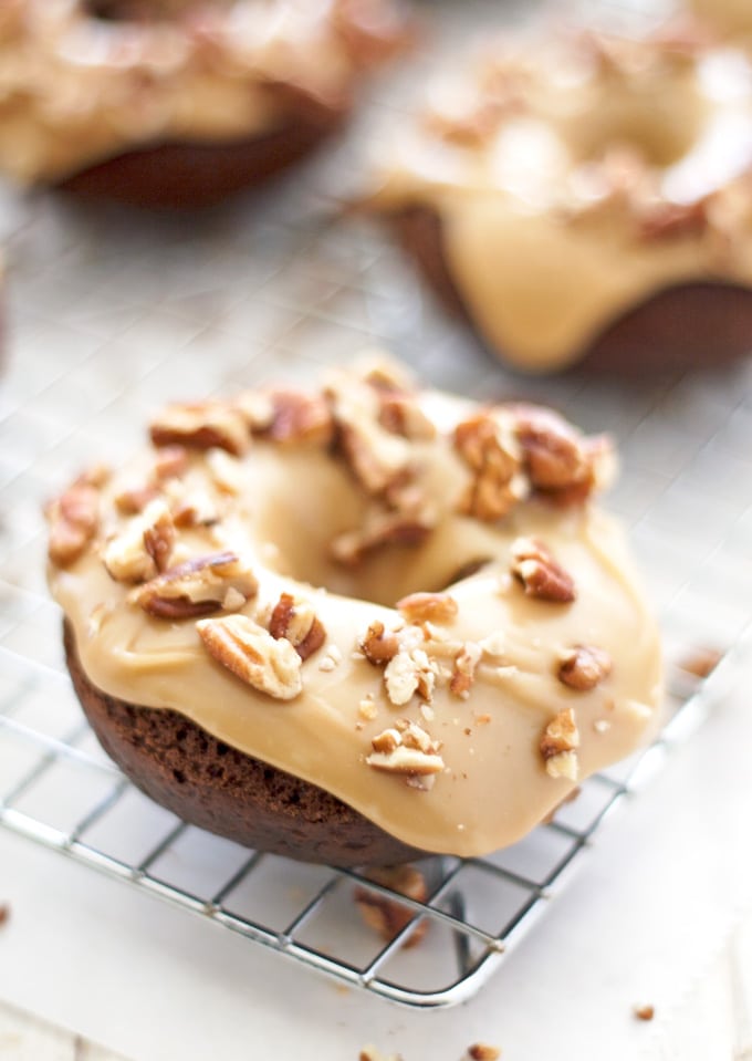 These turtle donuts start with a chocolate decadent donut, topped with caramel glaze and sprinkled with chopped pecans. | ahappyfooddance.com